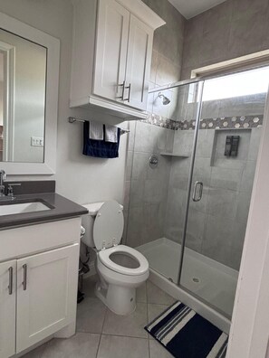 Ein Badezimmer mit Toilette, Waschbecken und Duschbereich.