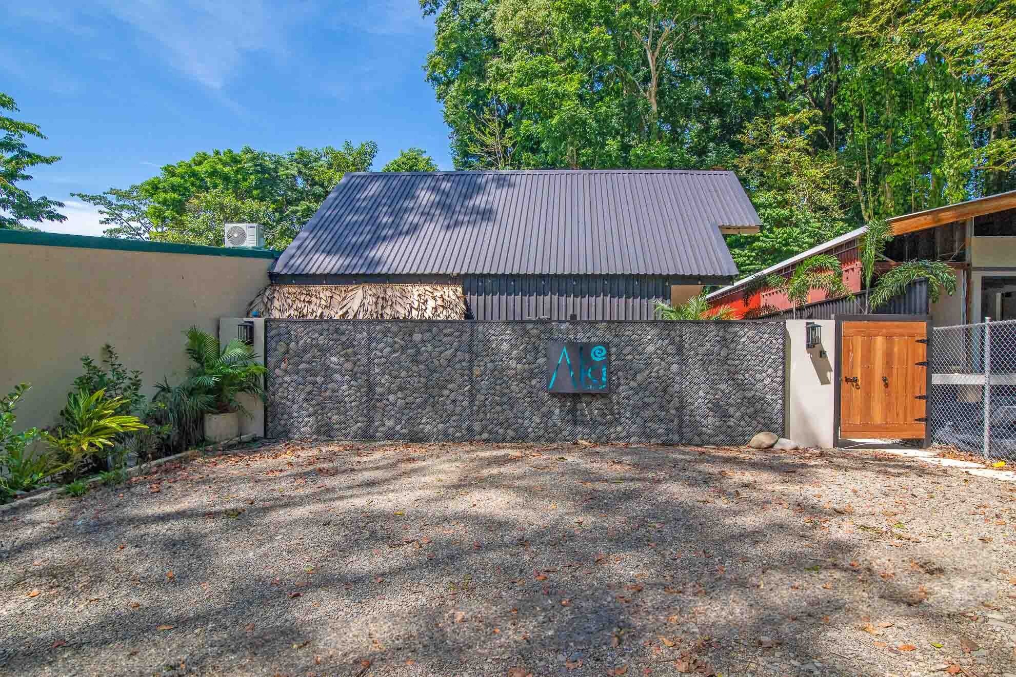 A house with a stone wall, a wooden door, and a metal gate.