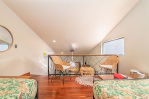 A room with two wicker chairs, a small table, and a bed with a patterned bedspread. - Aloki Wim 4 – A pasos de la Playa (Playa Chiquita)