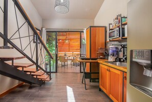 A modern kitchen with a built-in stove, a coffee maker, and a microwave. - Aloki Wim 4 – A pasos de la Playa (Playa Chiquita)