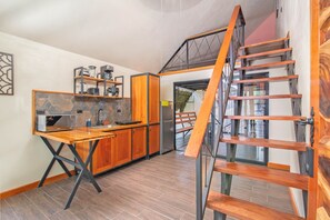 A modern kitchen with wooden cabinets, a built-in microwave, and a stainless steel refrigerator. - Aloki Kalok 3 - Refugio cerca de la playa (Playa Chiquita)