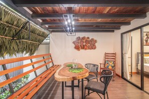 A dining area with a wooden table, chairs, and a hanging plant. - Aloki Villa – Sleeps 21 | Perfect for Friends & Families (Playa Chiquita)