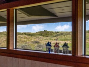 A view through a window with a rural landscape, including grass, trees, and a few small structures. - "Anita" - 400m from the sea by Interhome (Bindslev)