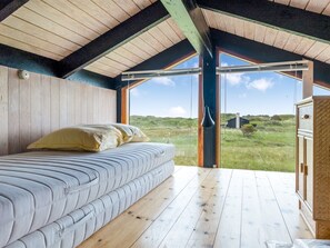 A bedroom with a bed, a view of the outdoors, and a wooden ceiling. - "Anita" - 400m from the sea by Interhome (Bindslev)
