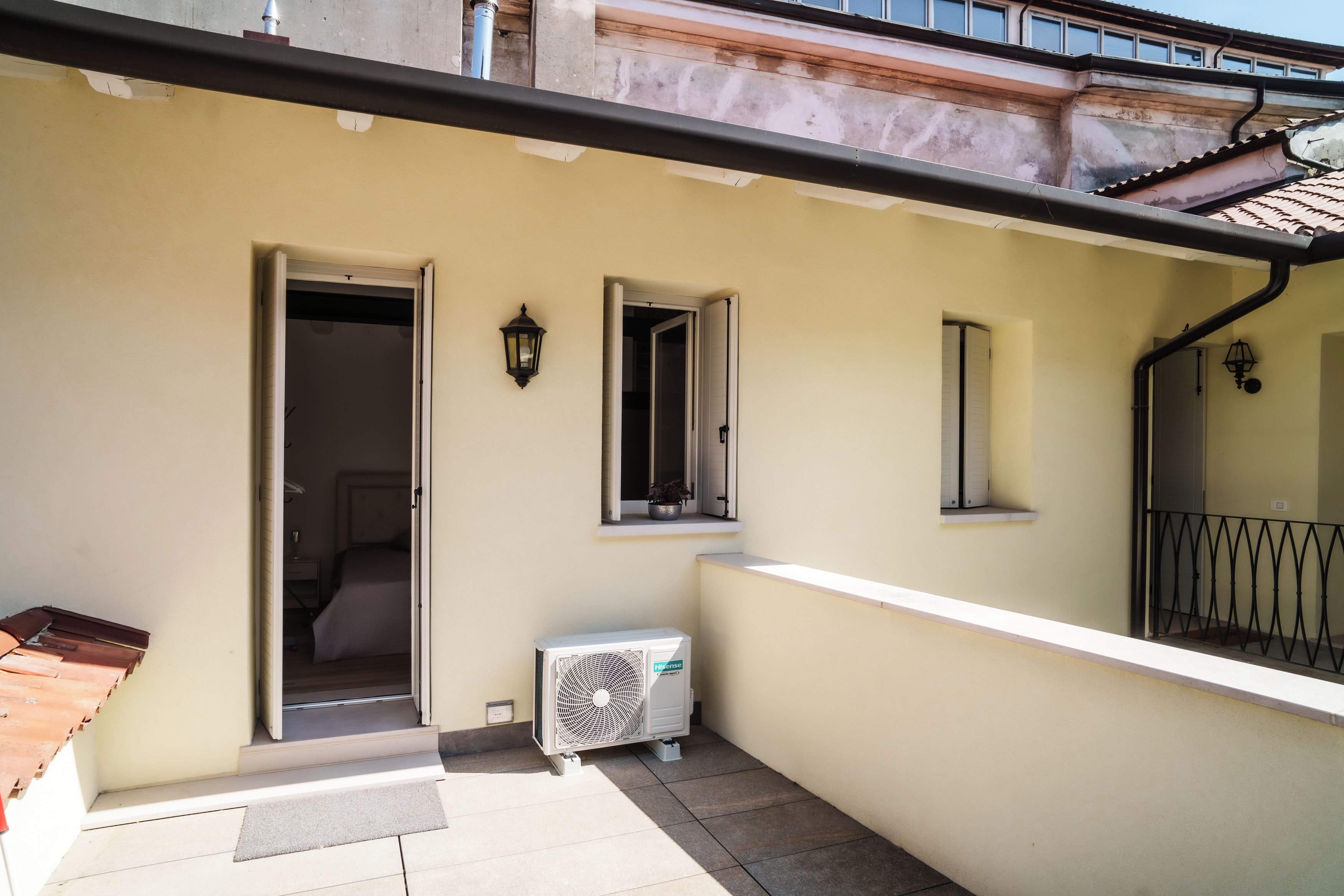En boligbygning med balkon, dør til et rum og et vindue med udsigt.