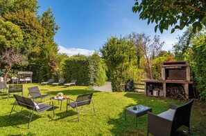 A backyard with a barbecue grill, outdoor furniture, and a small pond. - Kedimore - Red Apartment (Verona)