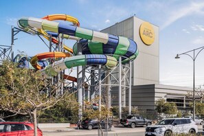 Un parque acuático con varias toboganes y un edificio con el rótulo 'COCKBURN ARC'.