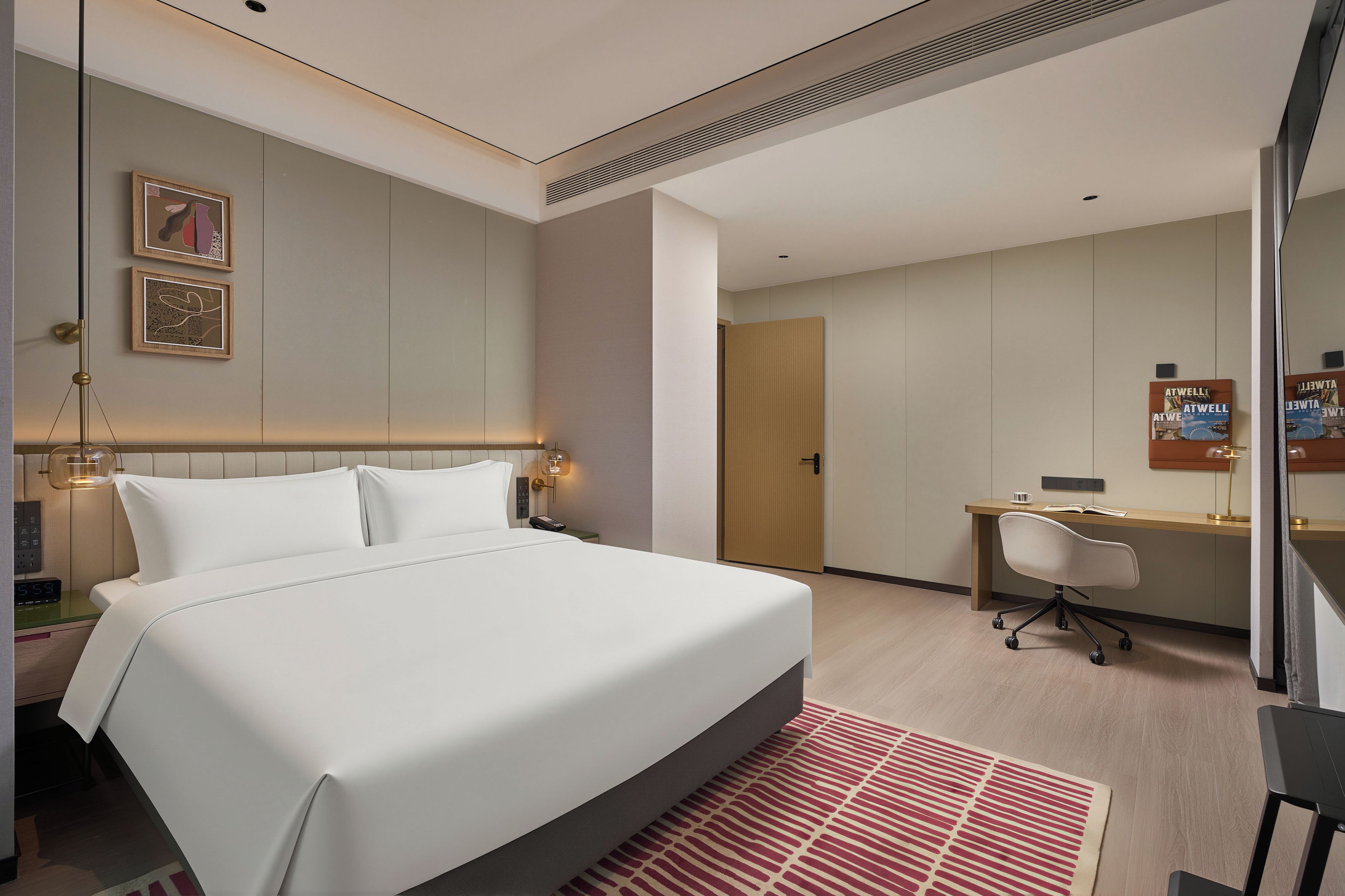 A modern hotel room with a large bed, bedside tables, a desk, and a chair.