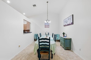 A dining area with a round table, chairs, a chandelier, a cabinet, and a framed picture on the wall. - 3BR Near Beach & Delray in Boynton Beach (Boynton Beach)
