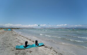 Ein Strand mit einem Surfbrett und einem Kajak im Sand.