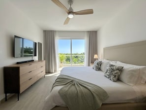 Ein Hotelzimmer mit Bett, Fernseher, Deckenventilator und Blick ins Freie.