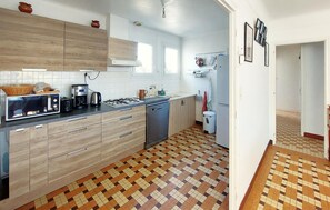 Une cuisine compacte équipée d’un four à micro-ondes, d’un grille-pain et d’une cuisinière à gaz.