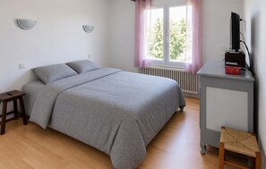 A bedroom with a bed, bedside tables, a desk, and a chair. - 3 bedroom beautiful home in Lamballe Armor (Lamballe Armor)