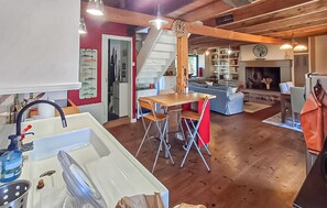 Eine geräumige Küche mit Essbereich, einer Treppe und einem Wohnzimmer mit Kamin.