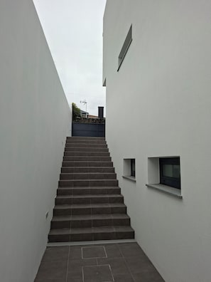 A staircase leading up to a building with a small window on the side. - LJR Accommodations São Vicente Ferreira (Ponta Delgada)