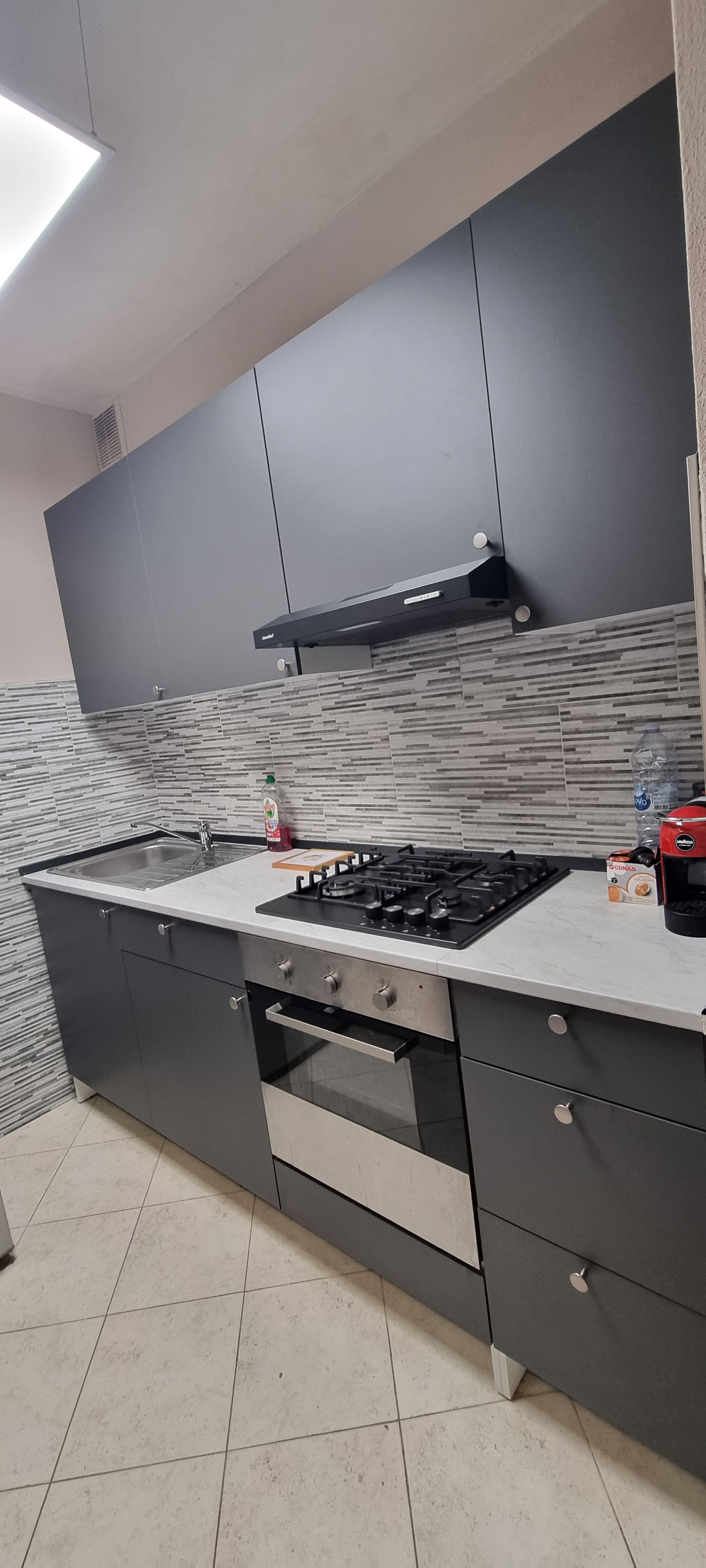 Una cucina moderna con piano cottura a gas, forno e microonde integrati.