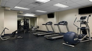 Ein Fitnessstudio mit Laufbändern, Crosstrainern und Krafttrainingsgeräten.