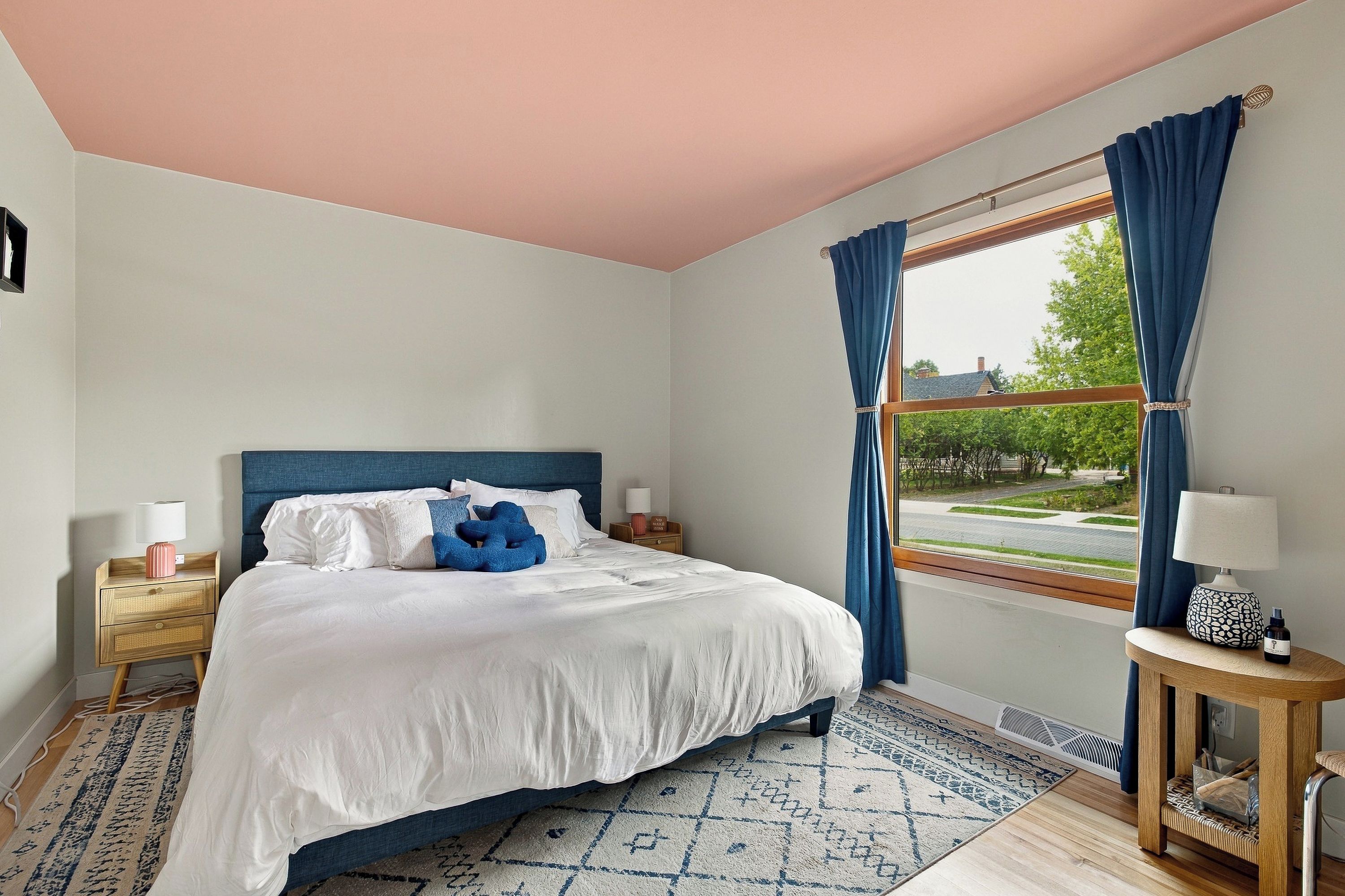 Bright, cozy bedroom with large windows and stylish blue accents