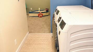 A laundry room with a washing machine and dryer, a welcome sign, and a life preserver on the floor.