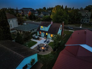 A residential area with houses, a fire pit, and outdoor seating.
