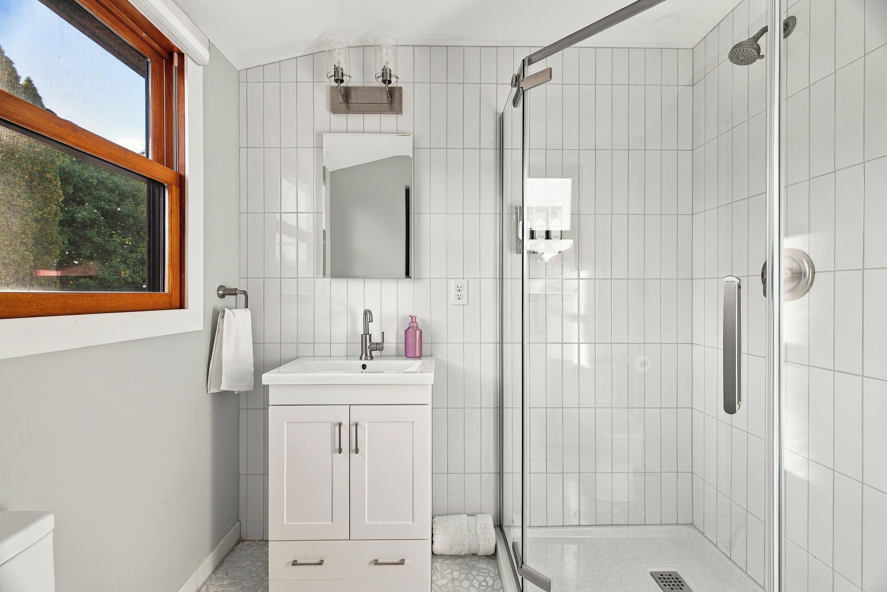 Bright modern bathroom with glass shower and plenty of natural light