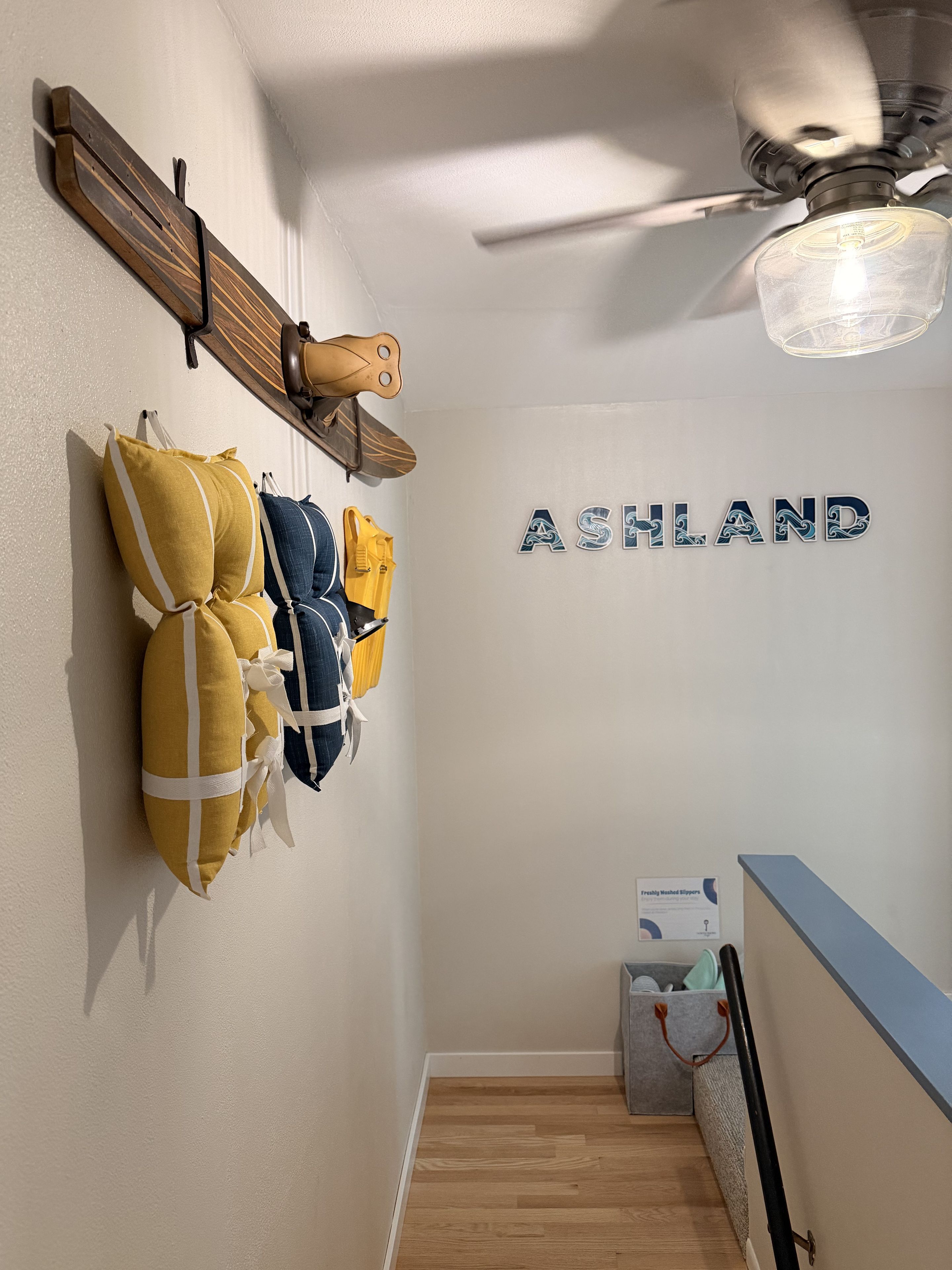 A hallway with a wall-mounted shelf holding a helmet and a sign that reads 'ASHLAND.'