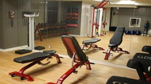 Et fitnessrum med træningsudstyr, et spejl og et vindue.