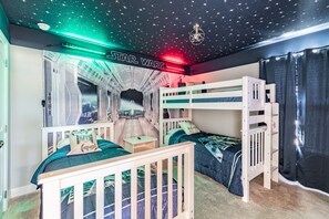 A Star Wars-themed bedroom with bunk beds, a space-themed ceiling, and a Star Wars logo. - Magical Disney House-Pool & Hot Tub, Free Waterpark (Davenport)