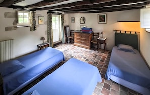 A room with two beds, a dresser, a desk, and a window with curtains. - Gite de la basse cour (BREIL)