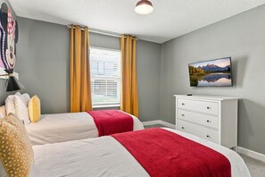 A bedroom with two beds, a dresser, a television, and a window with curtains. - Magical Getaway With Private Pool Top Location (Davenport)