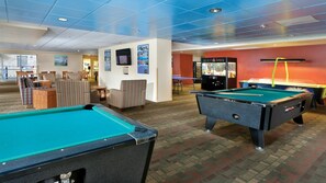 A pool table area with a billiards table, a seating area with striped chairs, and a snack bar. - Beachfront WorldMark Seaside Stay with Pools, Space & Family Fun by the Ocean (Seaside)