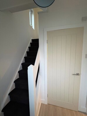 A staircase leading to a door with a white frame and a door handle. - Contractor Stay, Sleeps 5, Parking, WiFi, Halton (Halton)