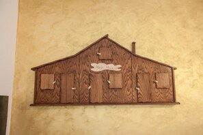 Een houten wanddecoratie in de vorm van een schuur met de tekst 'Hairt House' en zes kleine ramen.