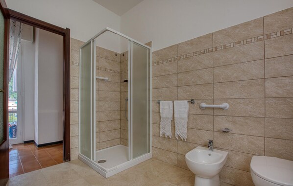 Ein Badezimmer mit Dusche, Bidet und Toilette.