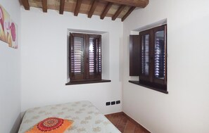 A bedroom with a bed, two windows, and a wooden ceiling beam. - Amazing home in Appignano with WiFi (Appignano)