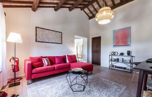 Ein modernes Wohnzimmer mit einem roten Sofa, einem geometrischen Couchtisch und einer Wanddekoration.