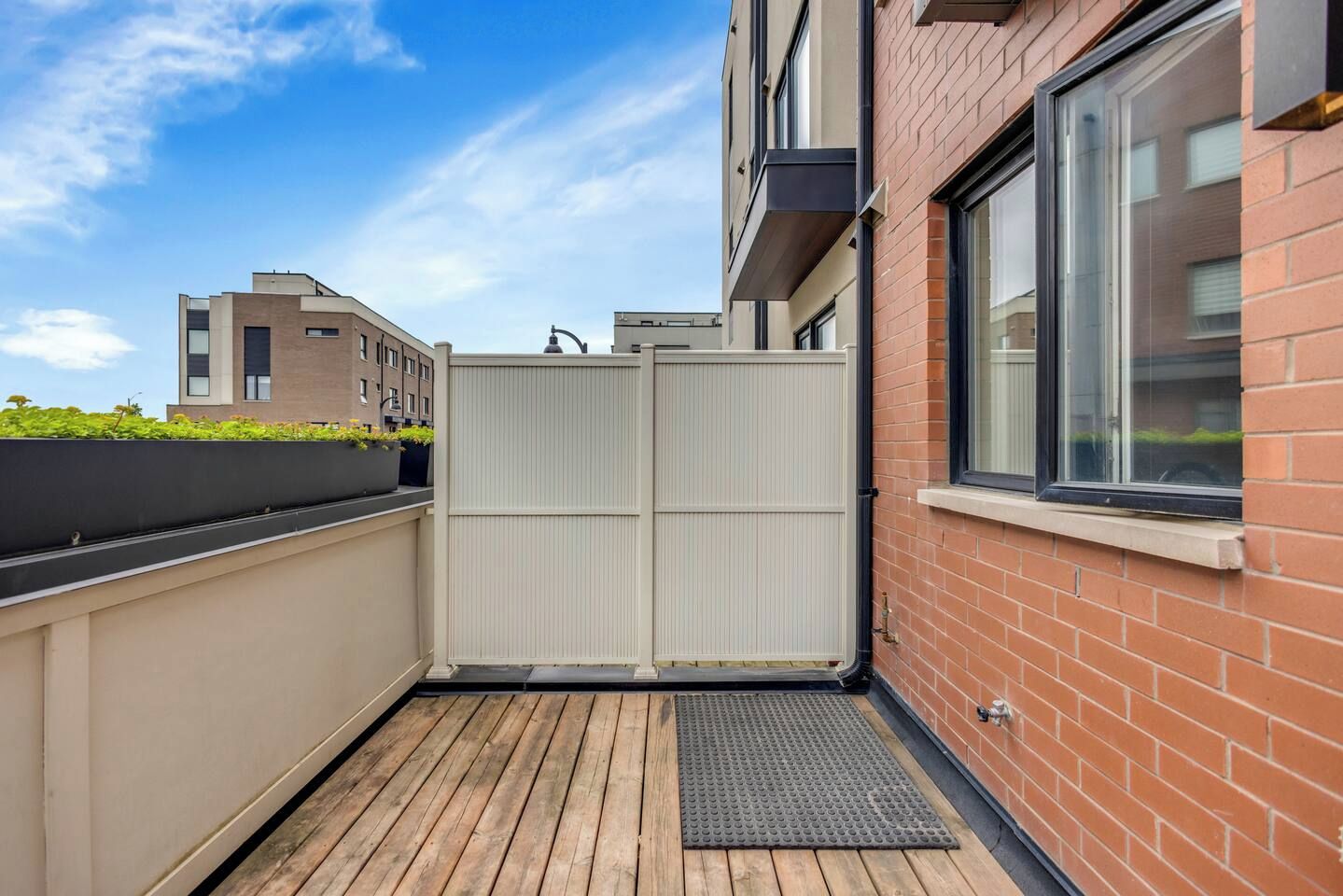 A modern building with a balcony, a metal fence, and a window.