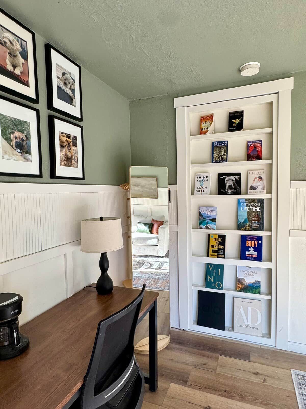Een knus hoekje om te lezen, met een houten tafeltje, een lamp en een boekenplank vol boeken.
