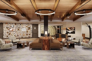A spacious lobby with a central seating area, a stone wall, and a modern ceiling design.