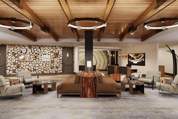 A spacious lobby with a central seating area, a stone wall, and a modern ceiling design.