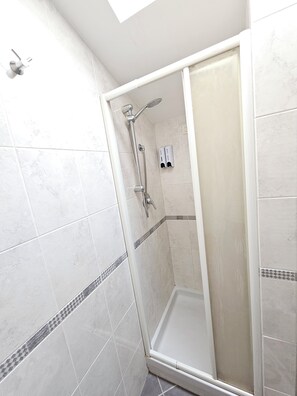 A walk-in shower with a glass door, tiled walls, and a showerhead. - A tastefully furnished penthouse with a stunning view and all the amenities (Molise)