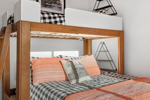 A bunk bed with a checkered bedspread and patterned pillows. - Hot tub - Fireplace - Game Room (Flagstaff)