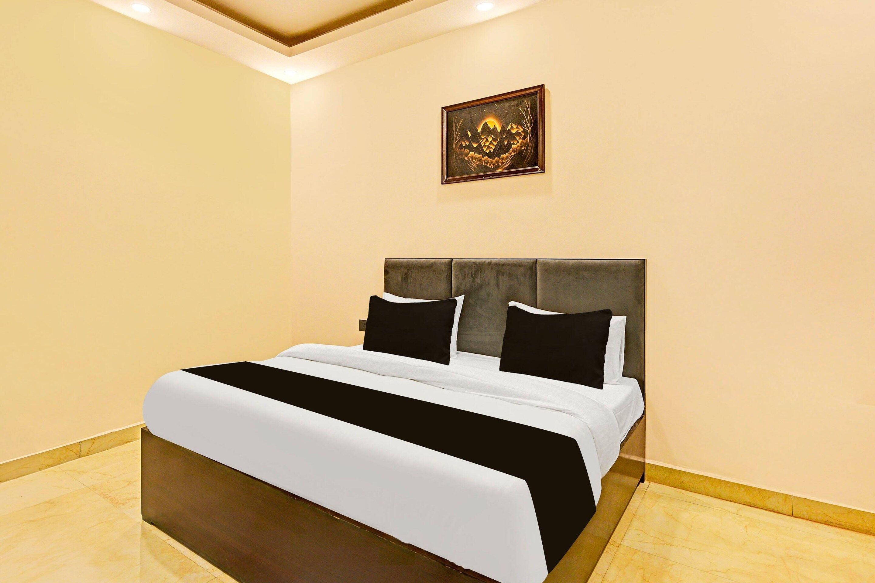 Een hotelkamer met een bed, een hoofdeinde en een kunstwerk aan de muur.