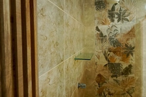 A bathroom with a tiled wall featuring a tropical leaf pattern. - Apartamentos y Villas D Angelo - Junior Suite 108 (Manzanillo)