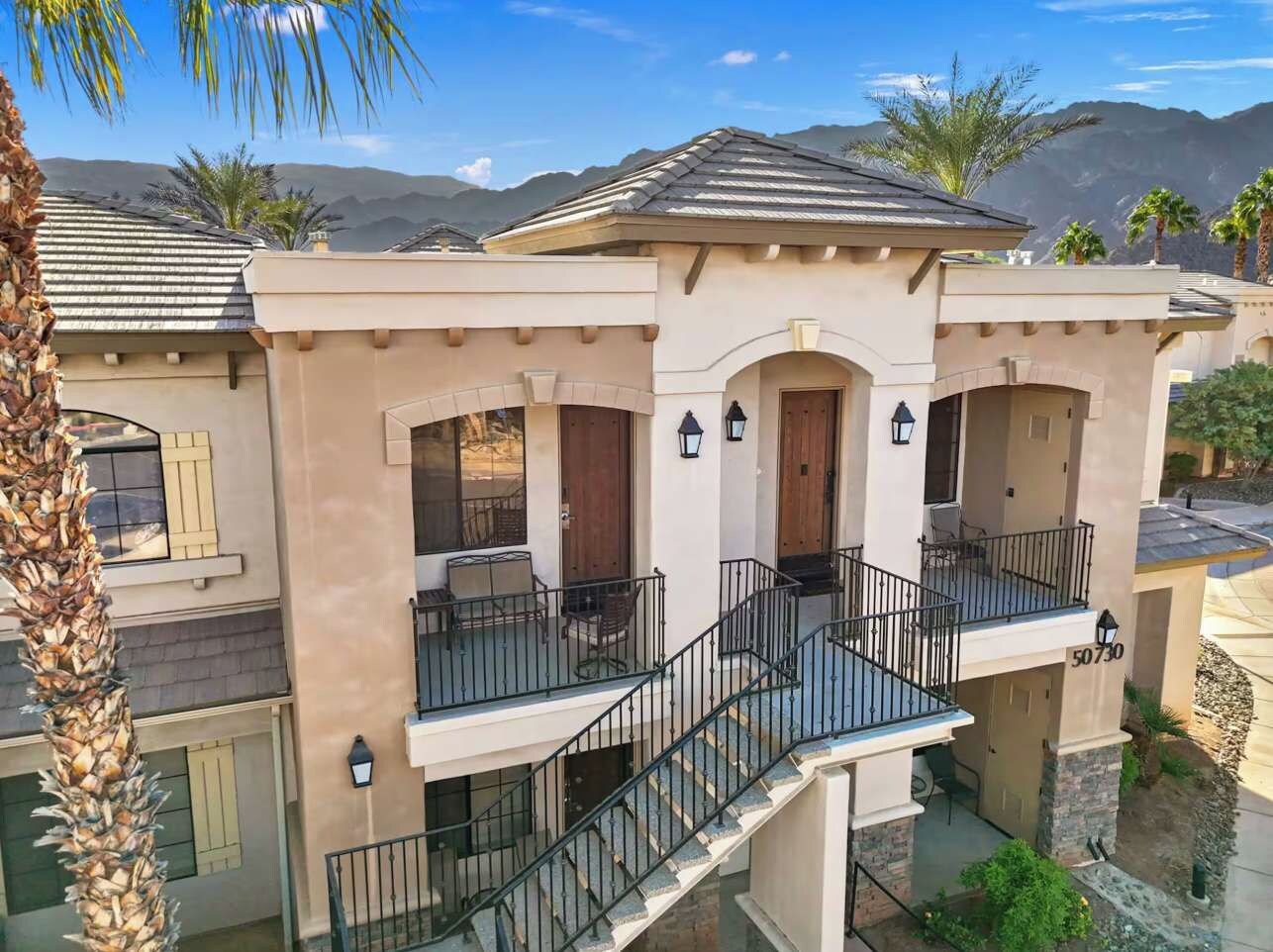 A multi-story residential building with a central courtyard, balconies, and a staircase.