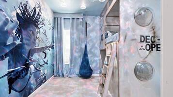 Una habitación con un mural, un sillón colgante y una pared con un logotipo.