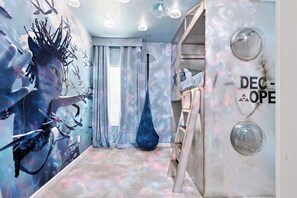 Una habitación con un mural, un sillón colgante y una pared con un logotipo.