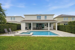 A modern two-story house with a covered patio, a swimming pool, and a well-maintained lawn. - Prime Location Near Disney with Private Theater (Kissimmee)