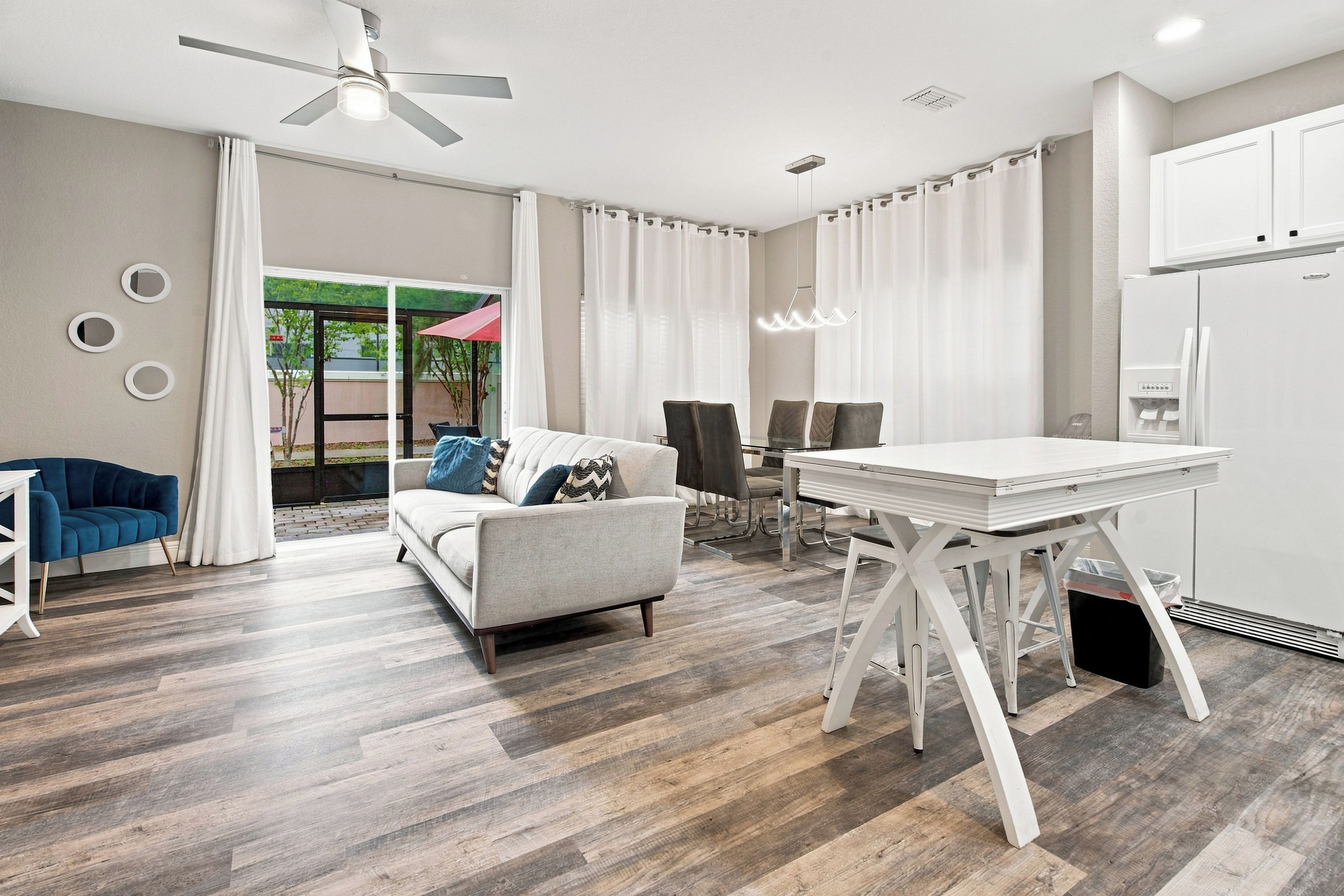 A modern living room with a sofa, dining table, and kitchen area.