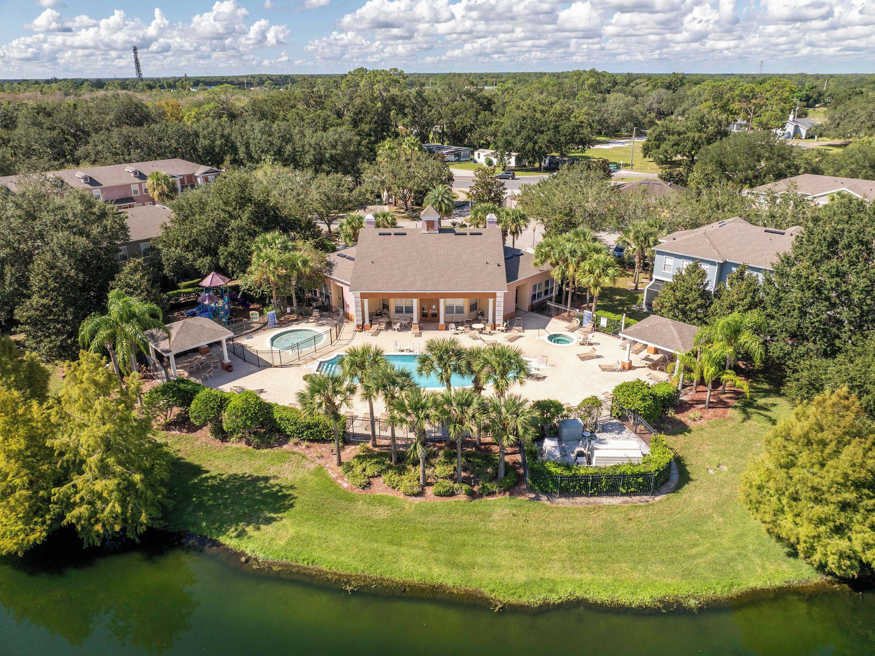 A residential area with a swimming pool, lounge chairs, and a gazebo.